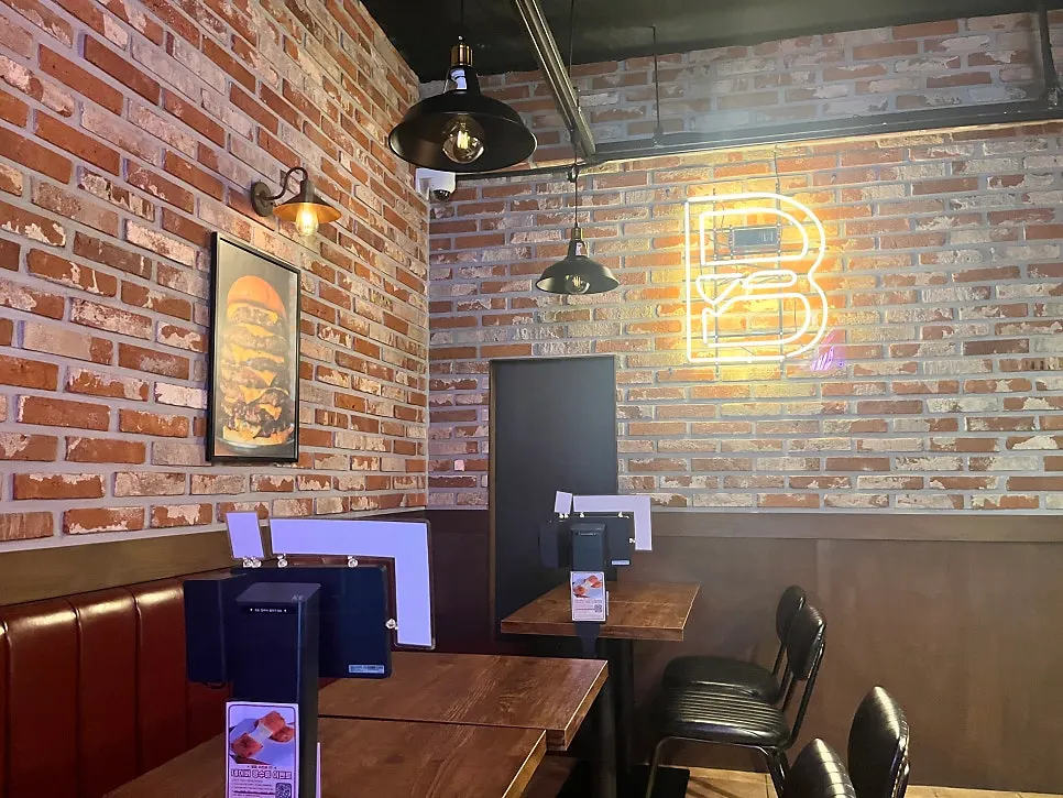 Interior of BAS Burger Seonyudo with brick walls and soft lighting