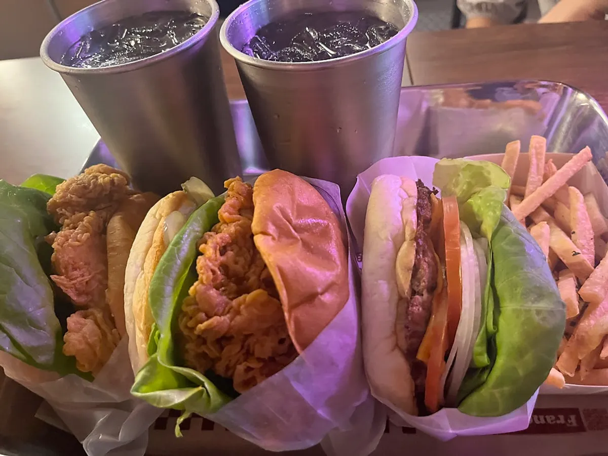 BAS Burger and chicken burger wrapped in paper with a side of fries