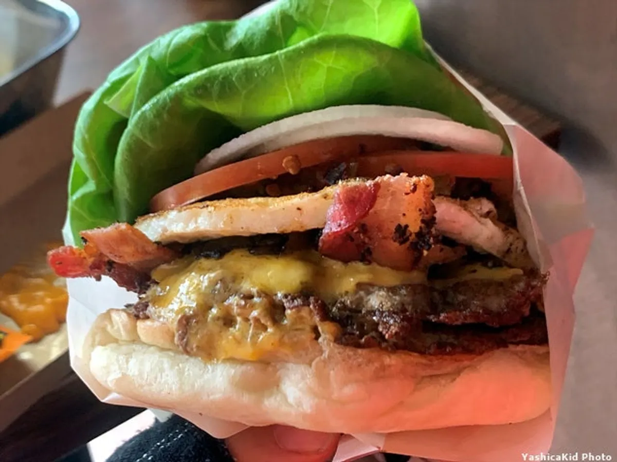 Tam-yok Burger topped with two thick patties and bacon