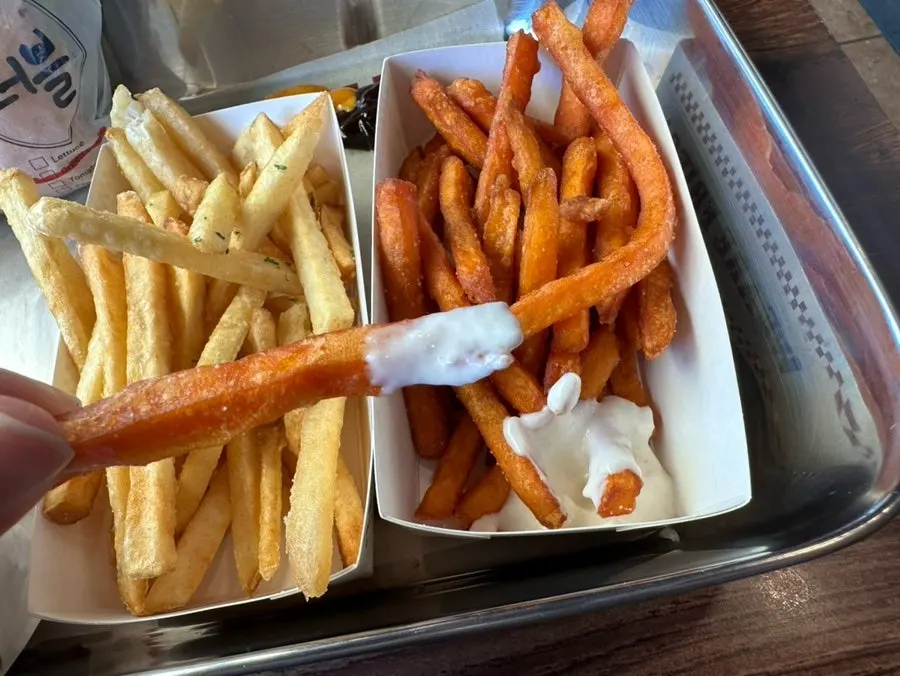 Sweet potato fries being dipped in ranch sauce