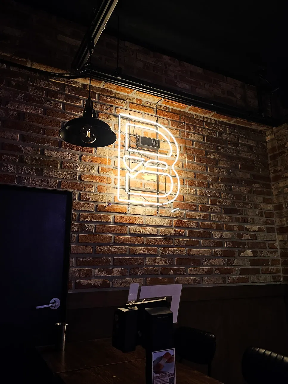 Neon 'B' sign on the wall