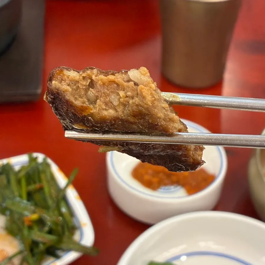 부추무침을 올린 수육 한 점
