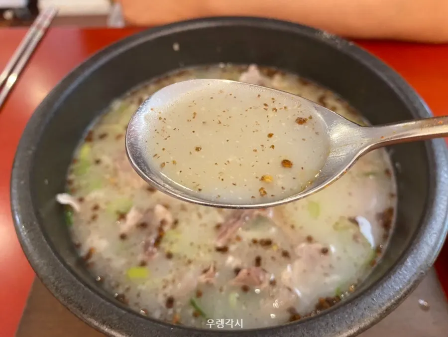 Deundeun Pork Gukbap putih dengan kuah pekat dan daun bawang