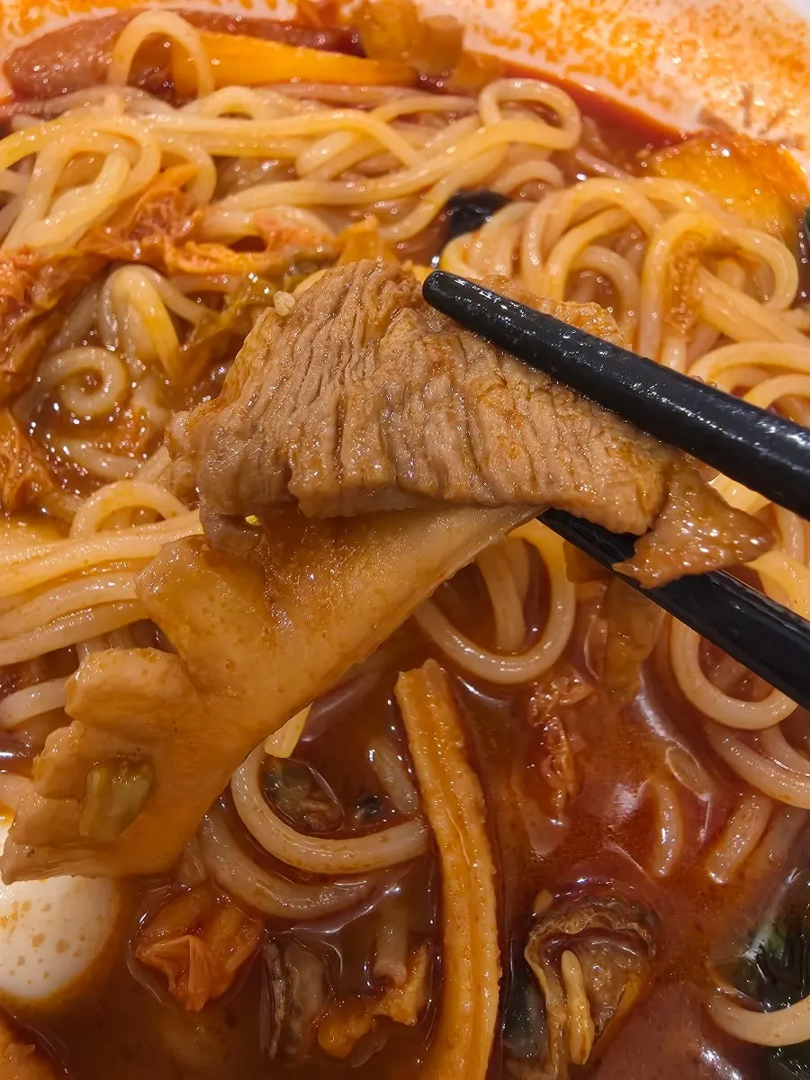 Lifting up a strand of jjamppong noodles