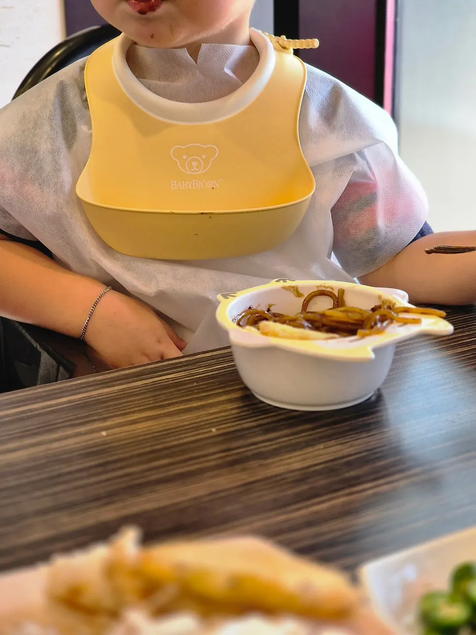 아기의자에 앉은 아기와 종이컵 물