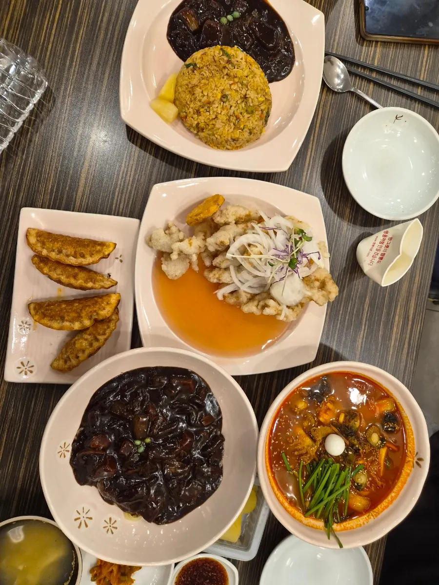 Table set with jjamppong, jjajangmyeon, and tangsuyuk