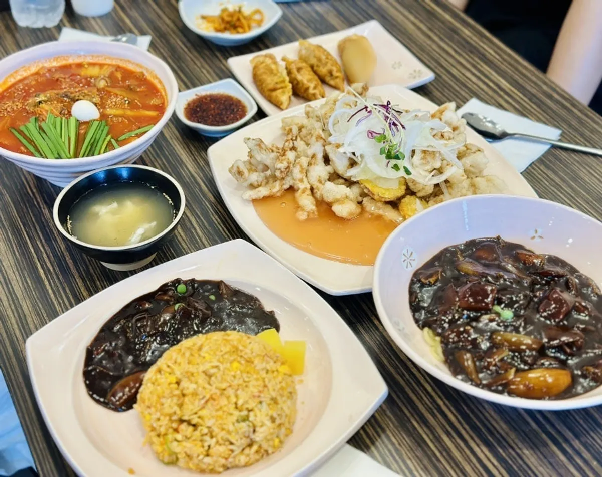 Table set with jjamppong, jjajangmyeon, crab fried rice, mara mandu and tangsuyuk