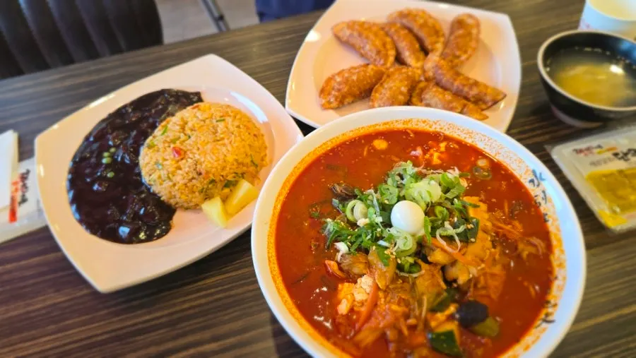 A spread of rice noodle jjamppong, crab fried rice, and jjamppong fried mandu