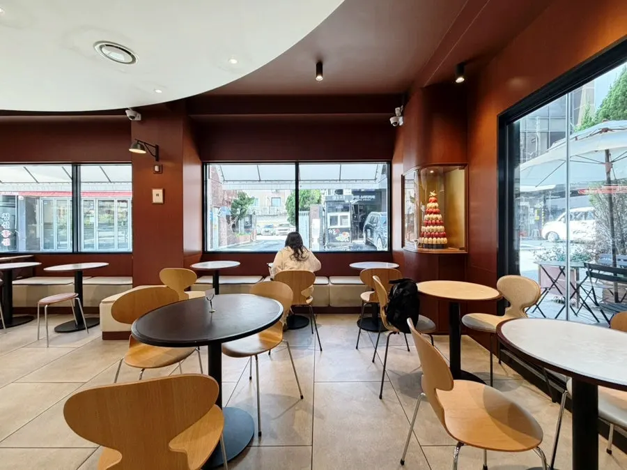 Window-side 2–4 person tables and the coffee bar along the wall