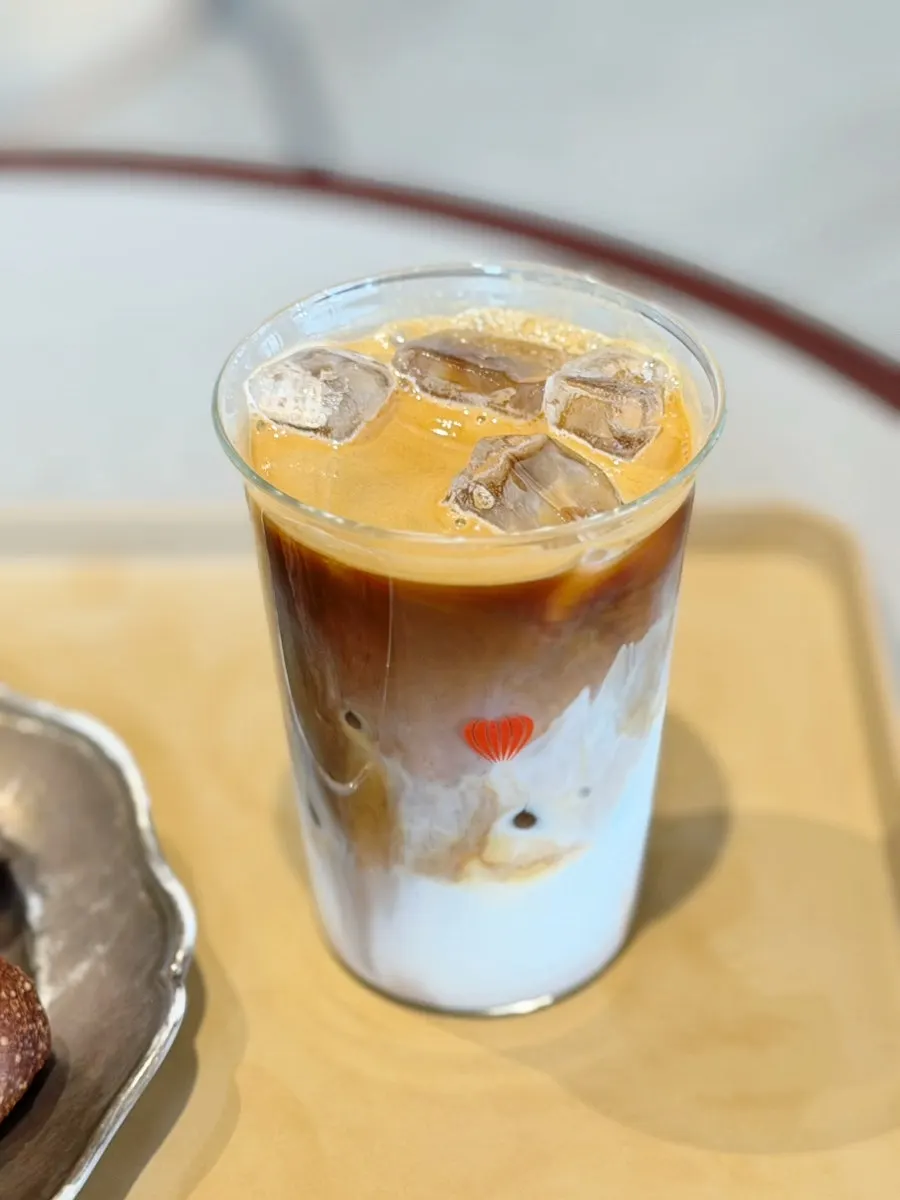 A cup of iced café latte made with noir beans