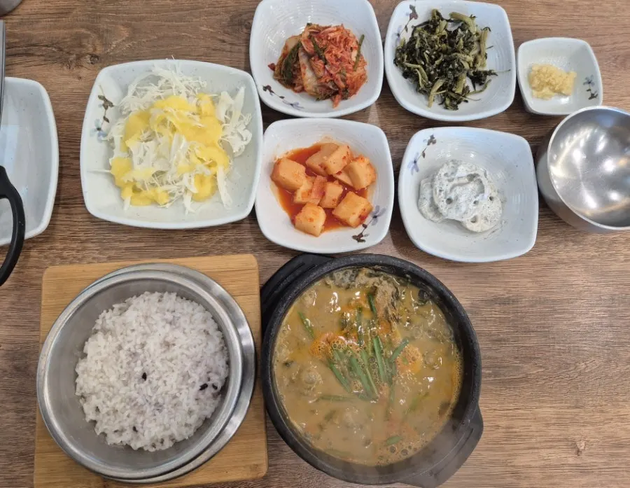 Abalone chueotang table setting served with stone-pot rice