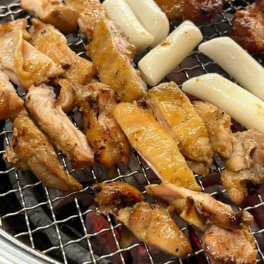 Pre-cooked dakgalbi placed on the charcoal grill