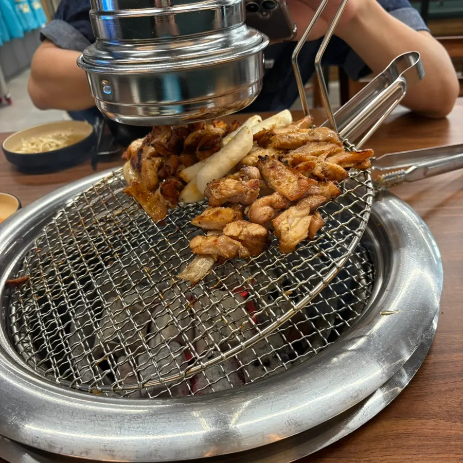 Fully cooked dakgalbi gathered away from the flame