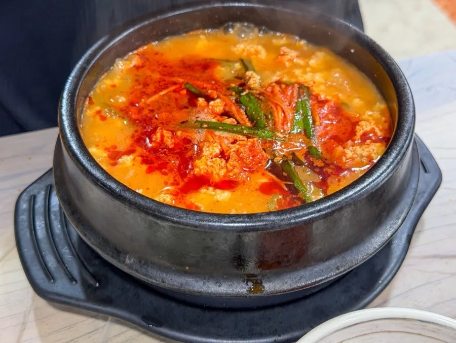 Jjamppong seafood sundubu simmering in a stone pot
