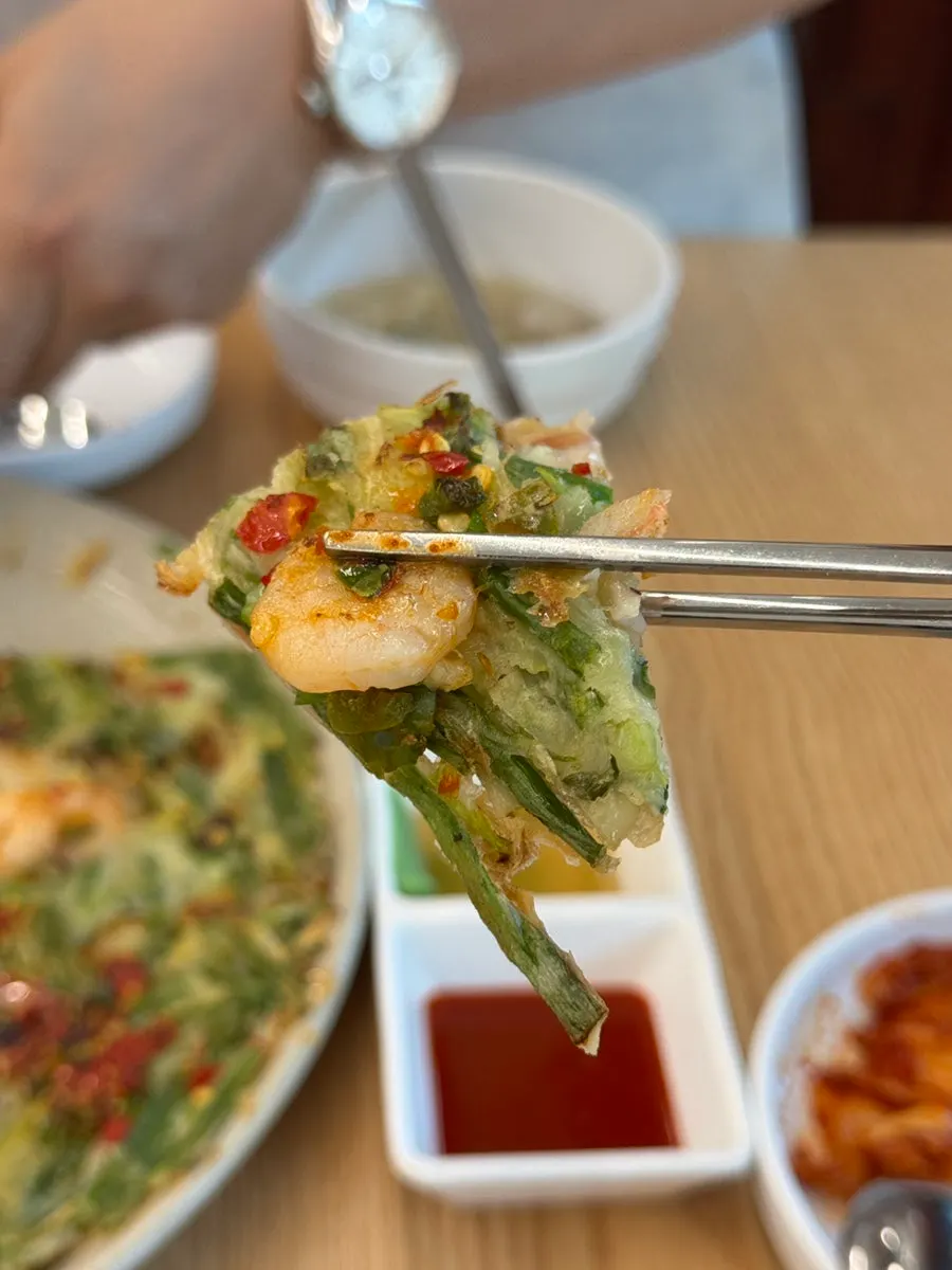 얇게 부쳐진 해물파전 한 젓가락