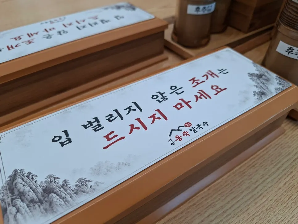 Menu board listing dongjuk kalguksu and seafood pancake