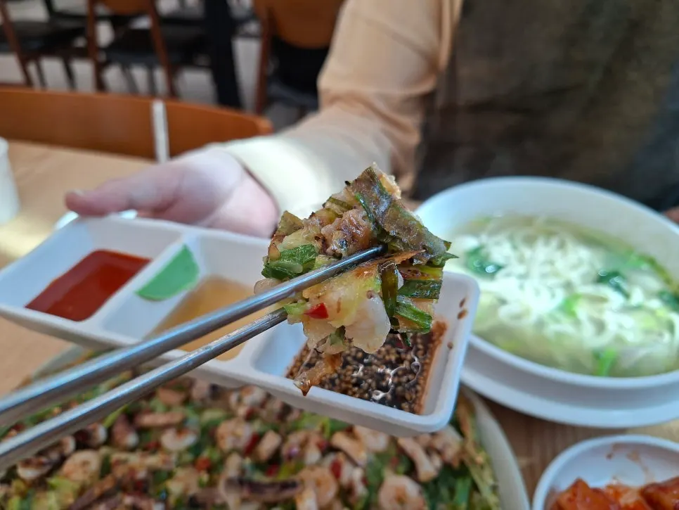 A piece of seafood pancake dipped in chojang sauce