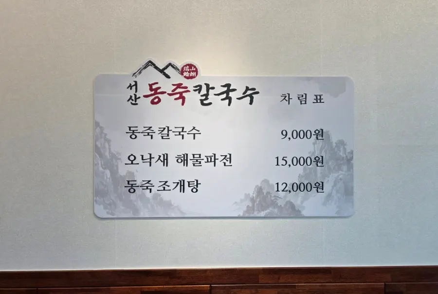 Menu board showing prices for dongjuk kalguksu and seafood pancake