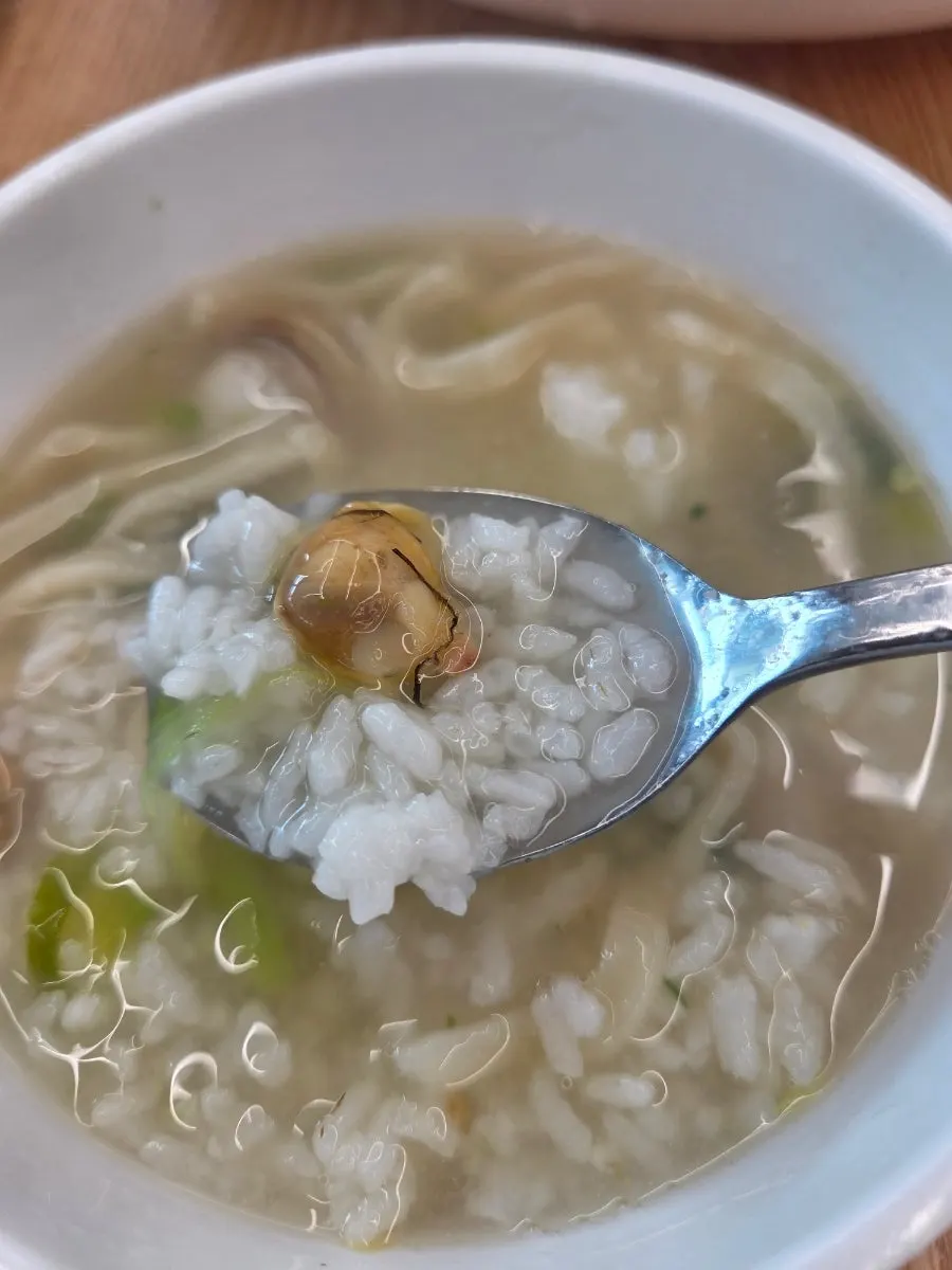 A spoonful of rice stirred into the dongjuk broth