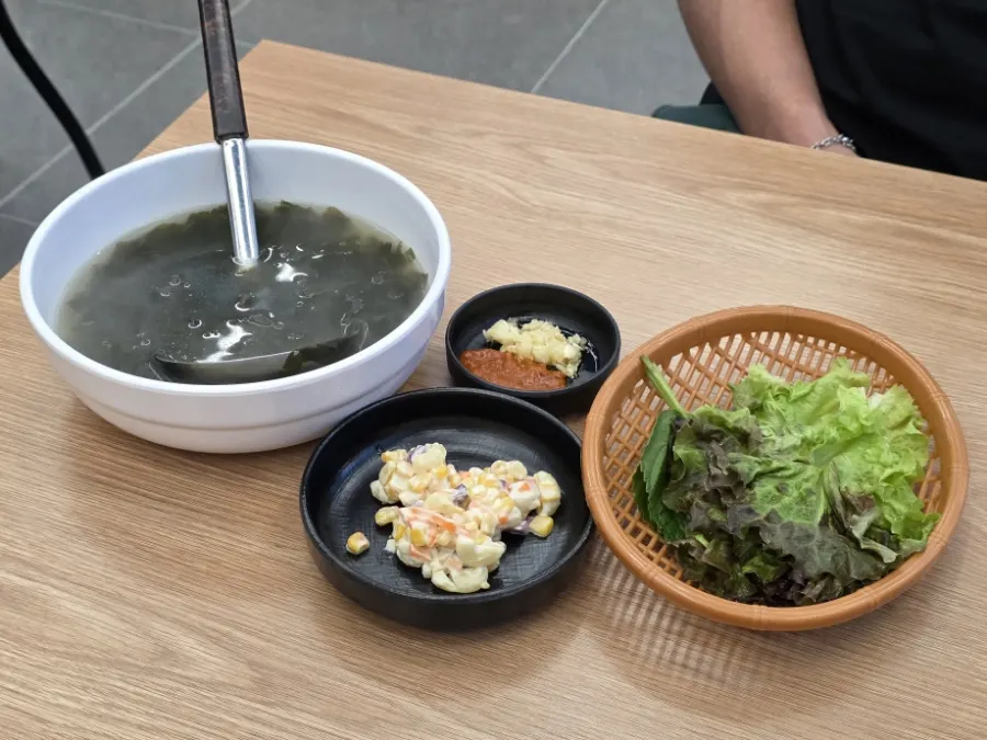 A spread of basic side dishes including seaweed soup and corn salad