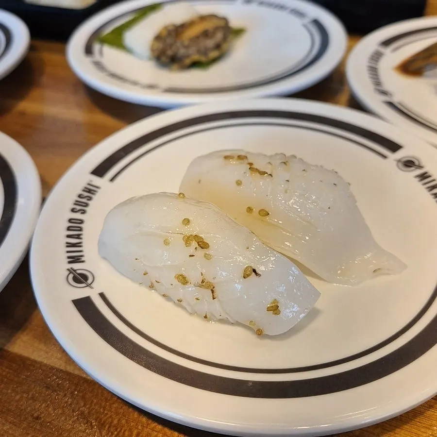 Platos de sushi de camarón pasando por la cinta