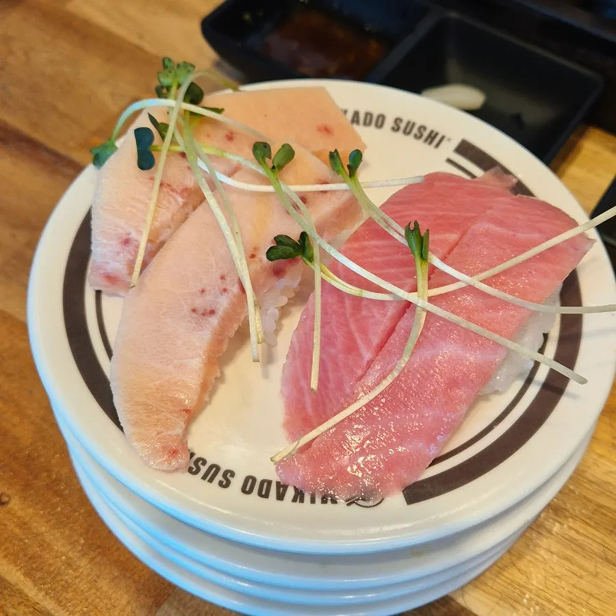 Cuatro piezas de sushi de panza de pez espada y atún rojo