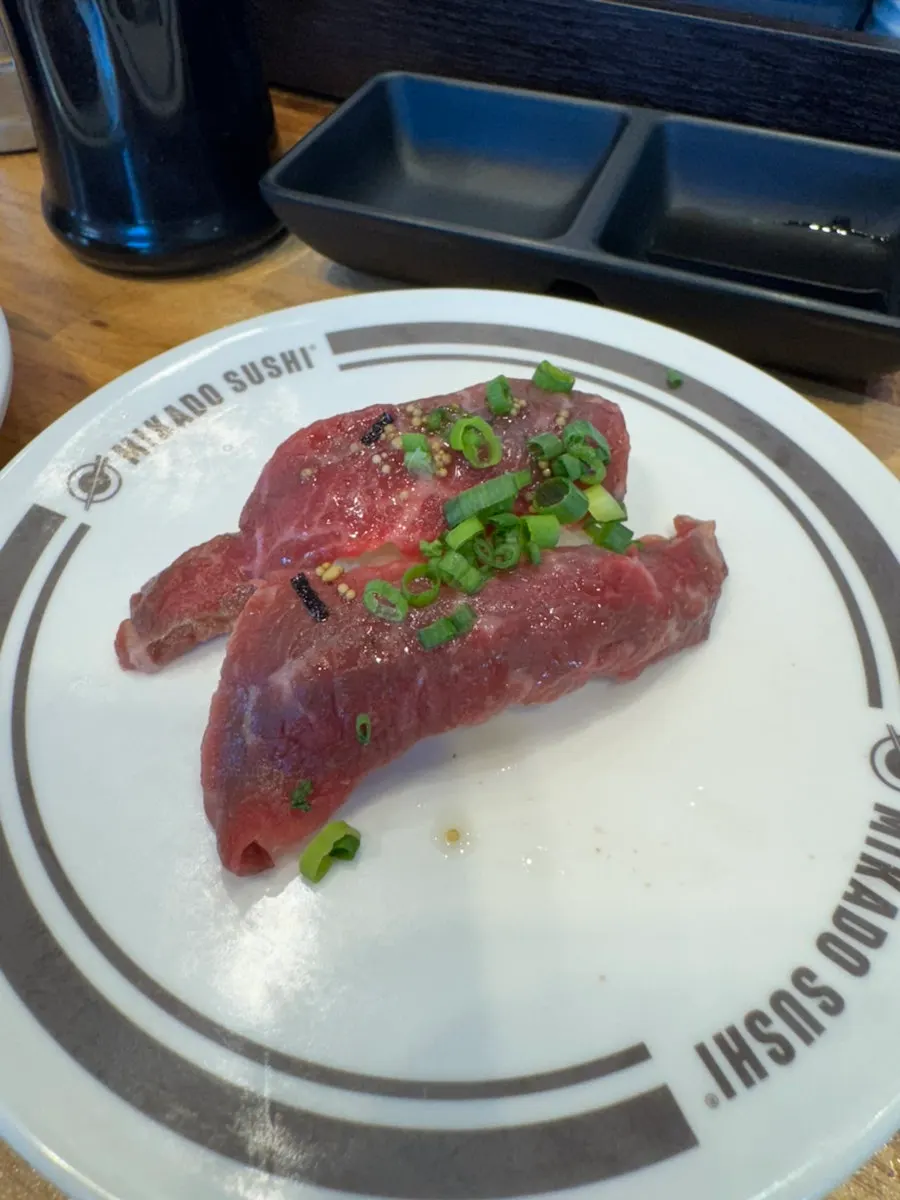 Plates of eel, beef tartare, and salmon sushi