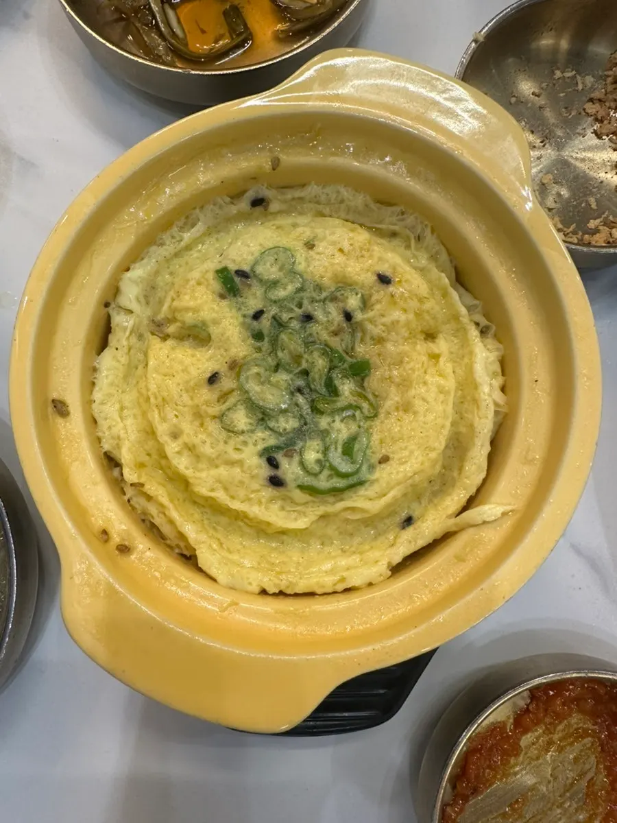 A bite of naengmyeon noodles topped with meat