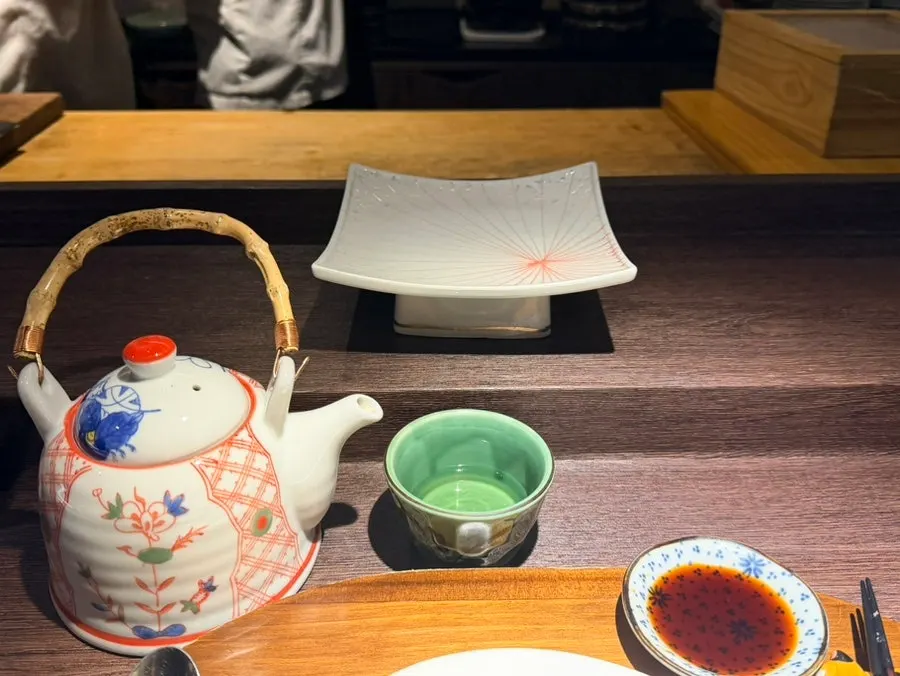 Dinner course table setting with soy sauce and teacups