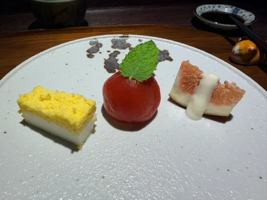 Three appetizers: castella rolled egg, tomato, and fig cream cheese