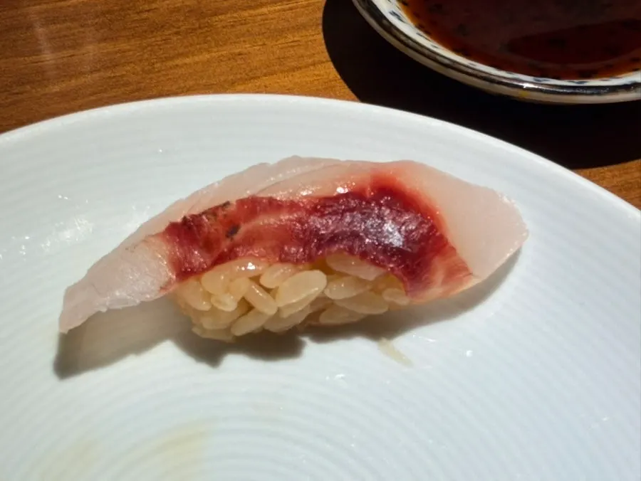 White-fleshed fish sushi over brown sushi rice