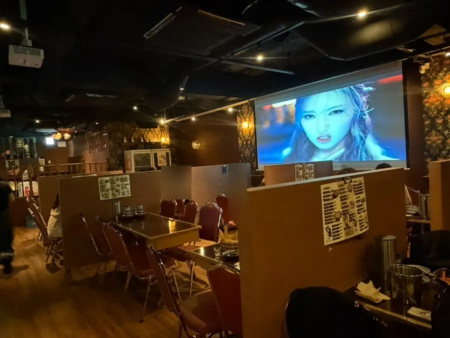 Inside the restaurant with K-pop music videos playing