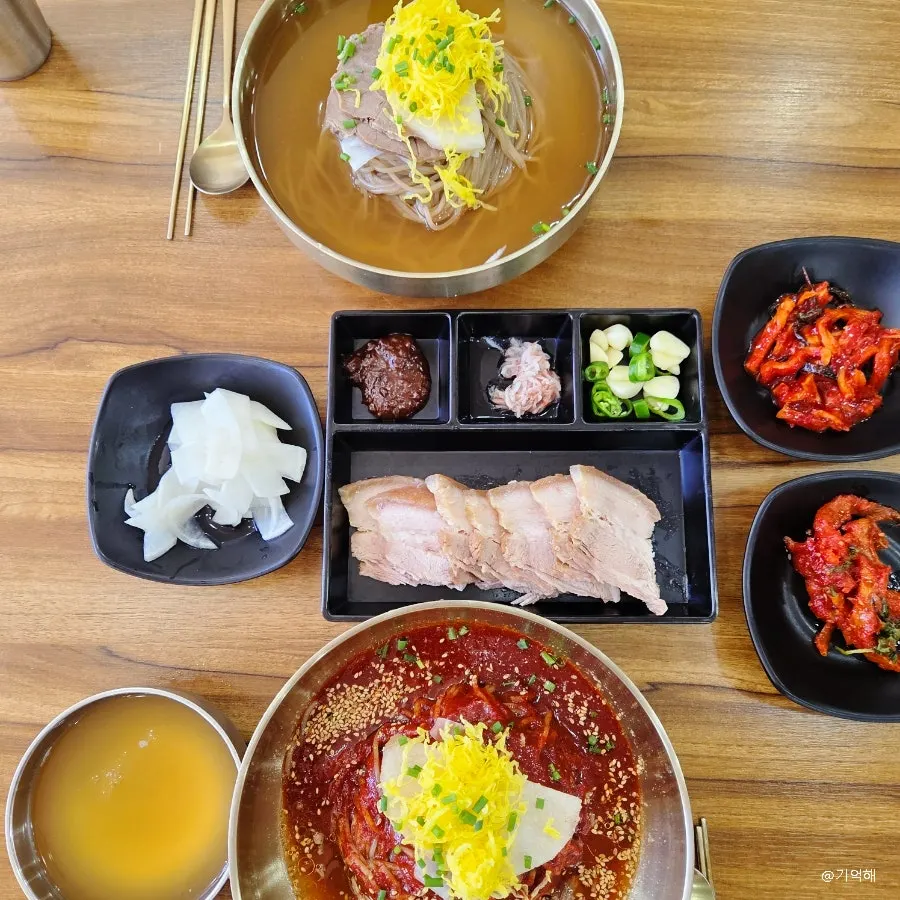 A table filled with naengmyeon and boiled pork