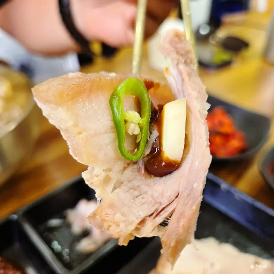 A piece of boiled pork topped with chili and garlic