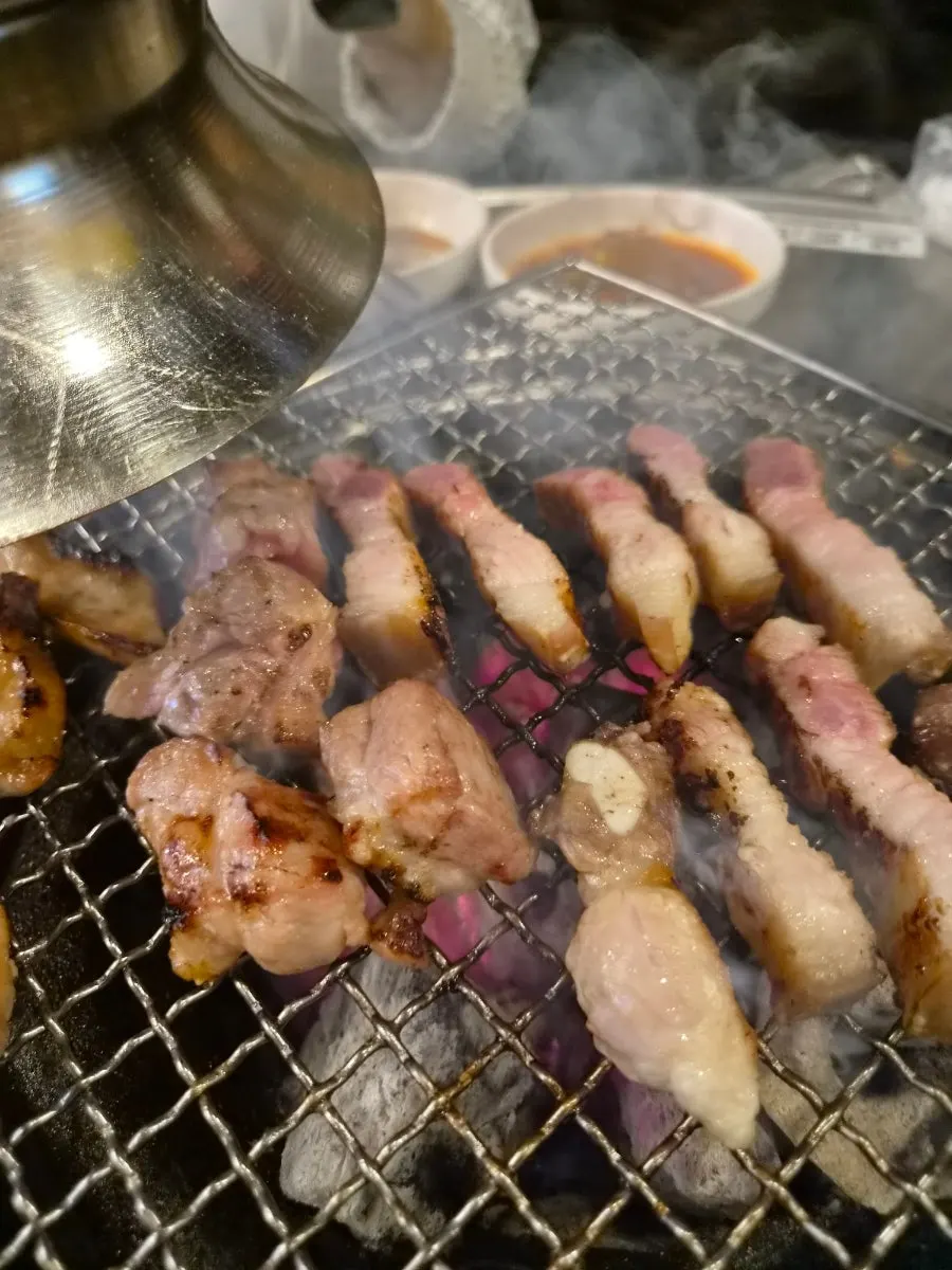 Picking up a piece of charcoal-grilled meat