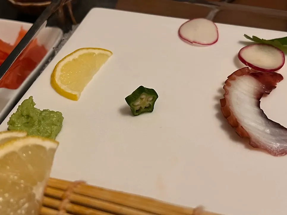 A plate of sashimi decorated with okra
