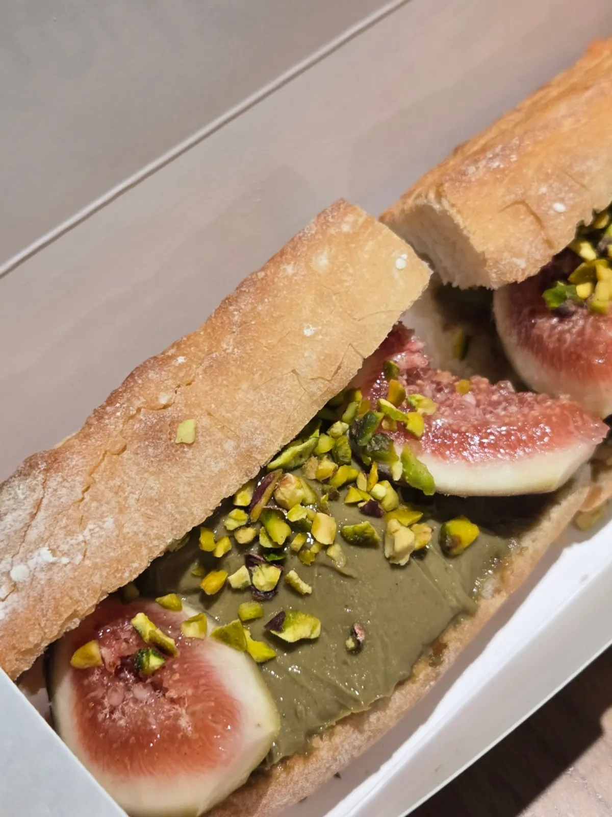 Fig baguette generously spread with pistachio tofu cream