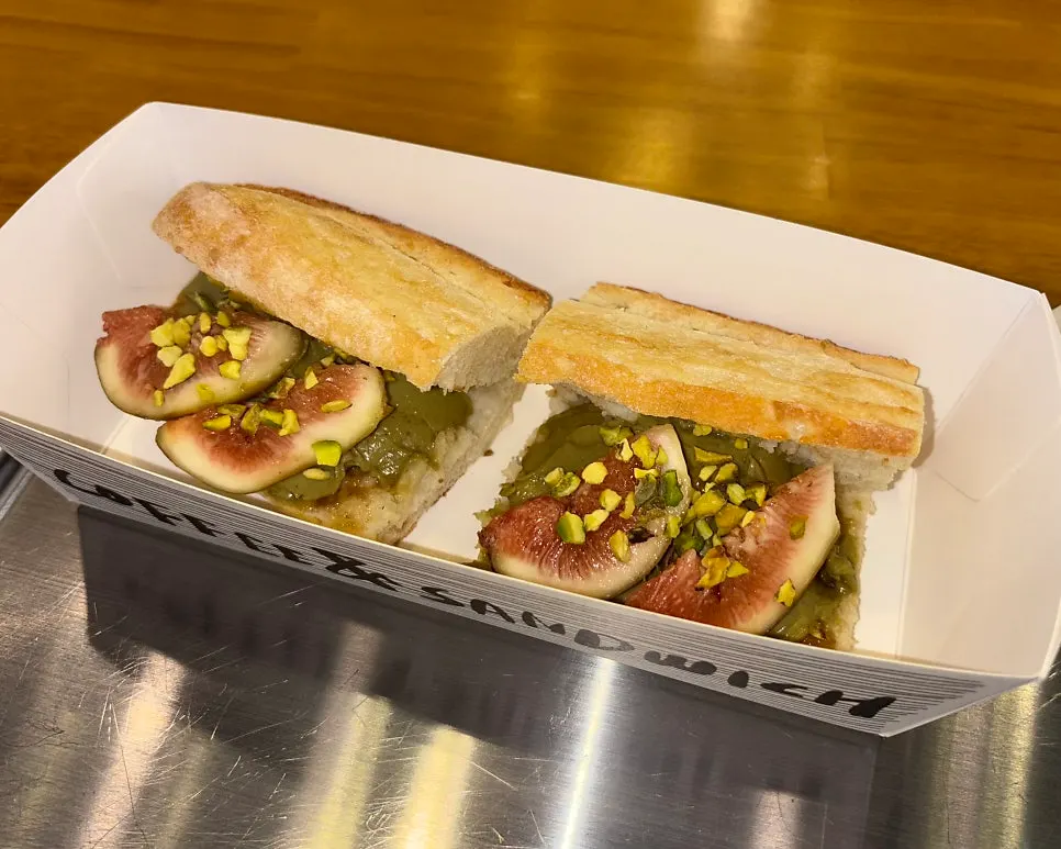 Fig baguette sandwich topped with crushed pistachio