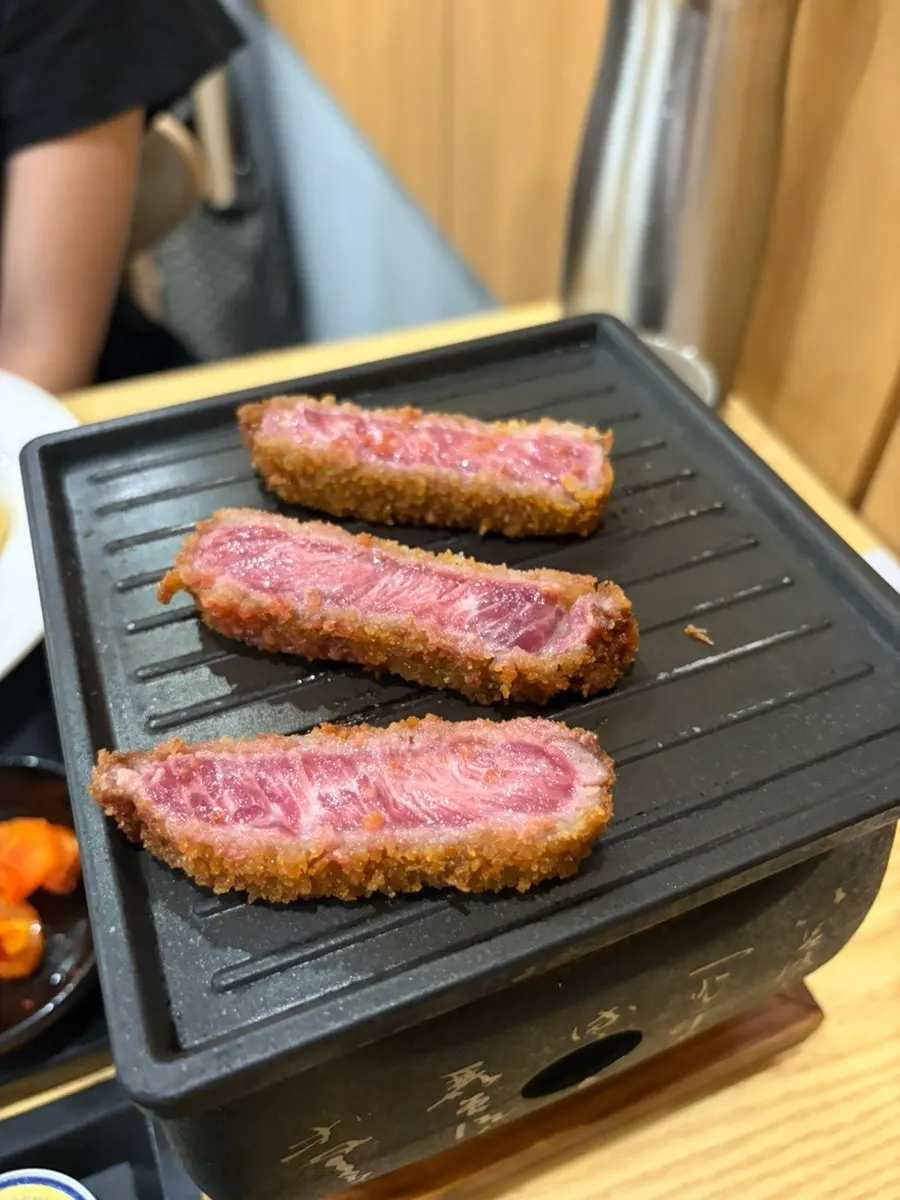 작은 화로 불판에 규카츠 한 조각을 올린 모습