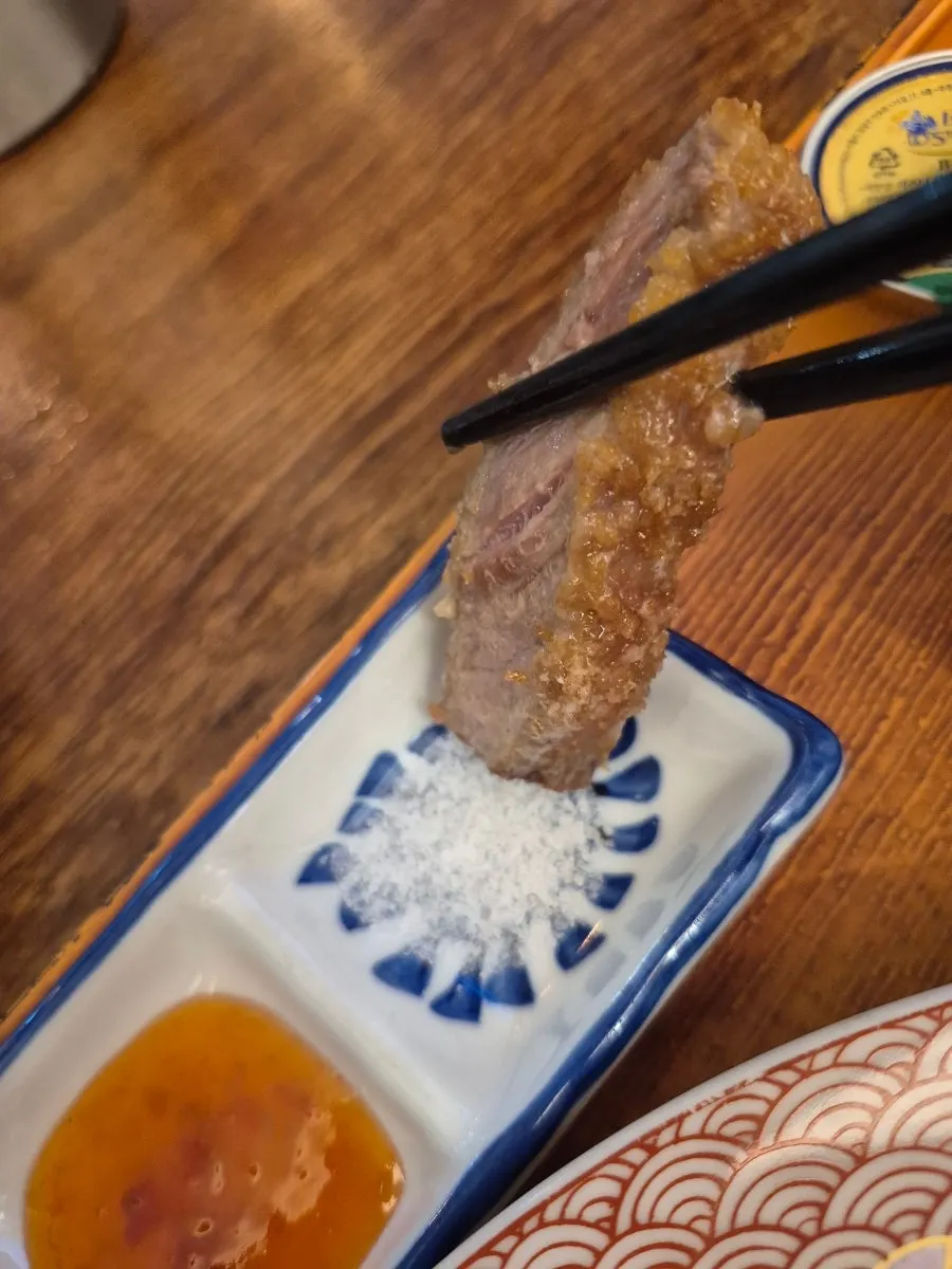 A slice of gyukatsu topped with wasabi