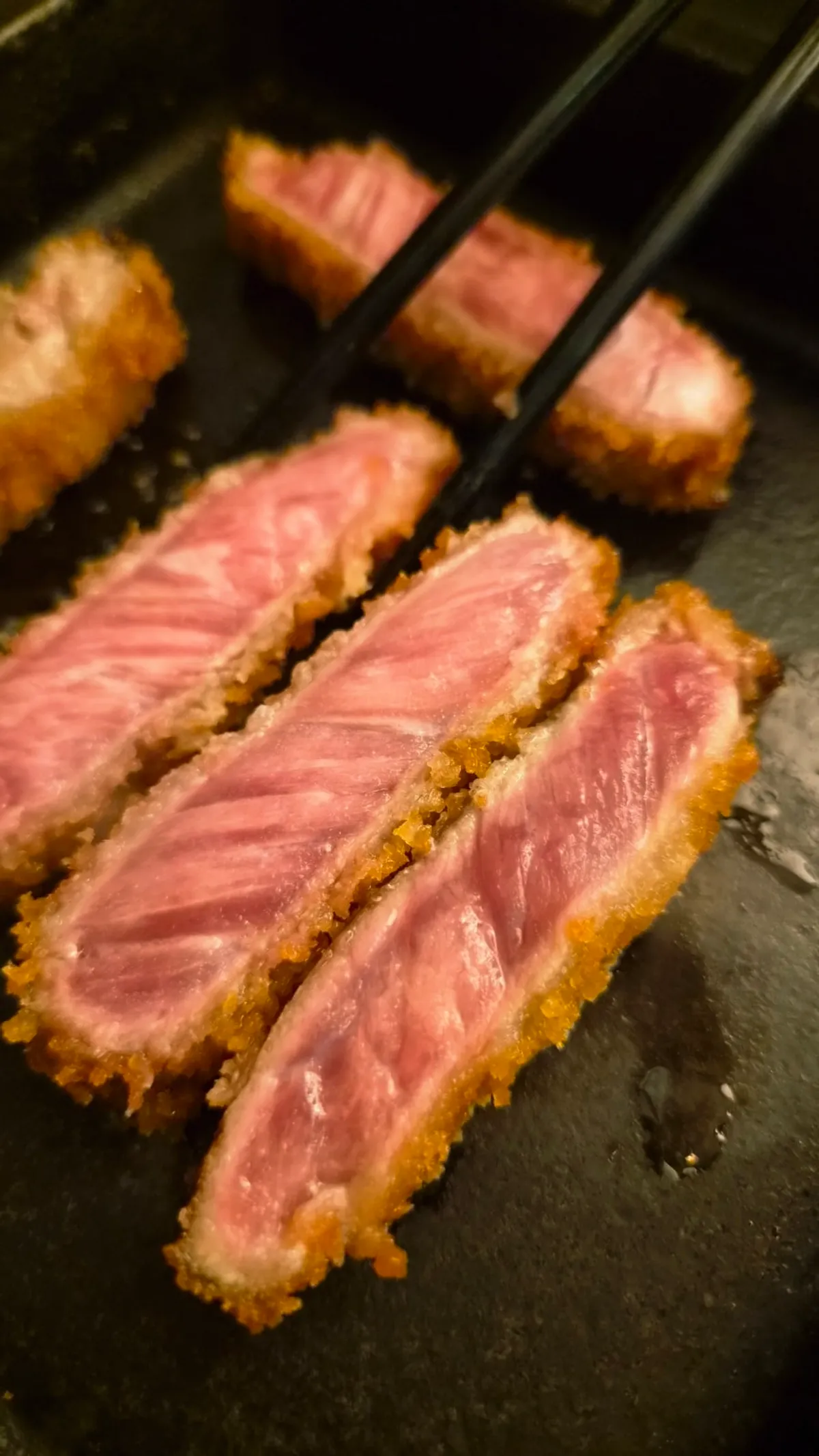 A piece of gyukatsu eaten right off the butter grill