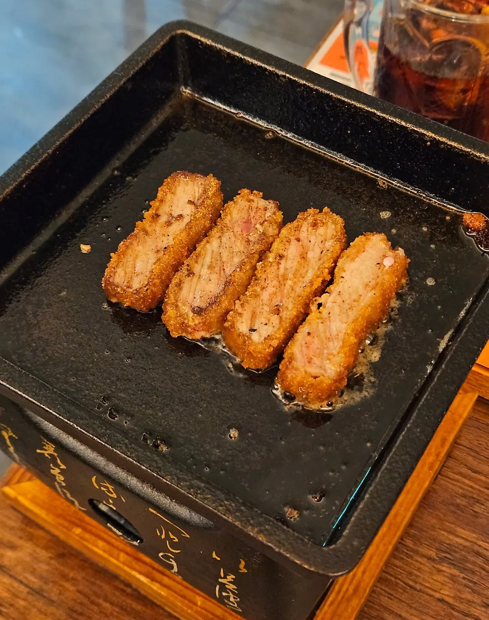 Several pieces of gyukatsu on the grill at once