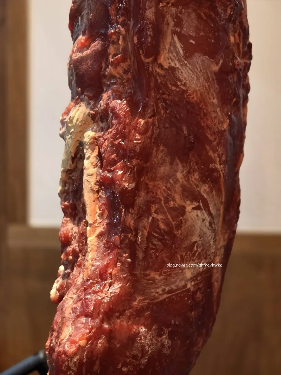 Large whole cut of meat hanging in the store