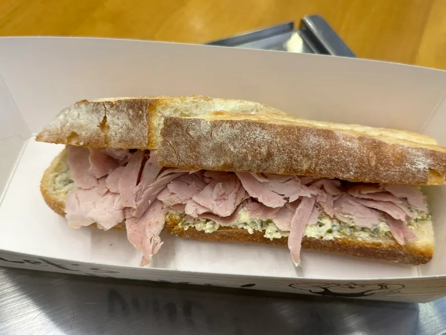 A bite taken out of the jambon jalapeño baguette sandwich