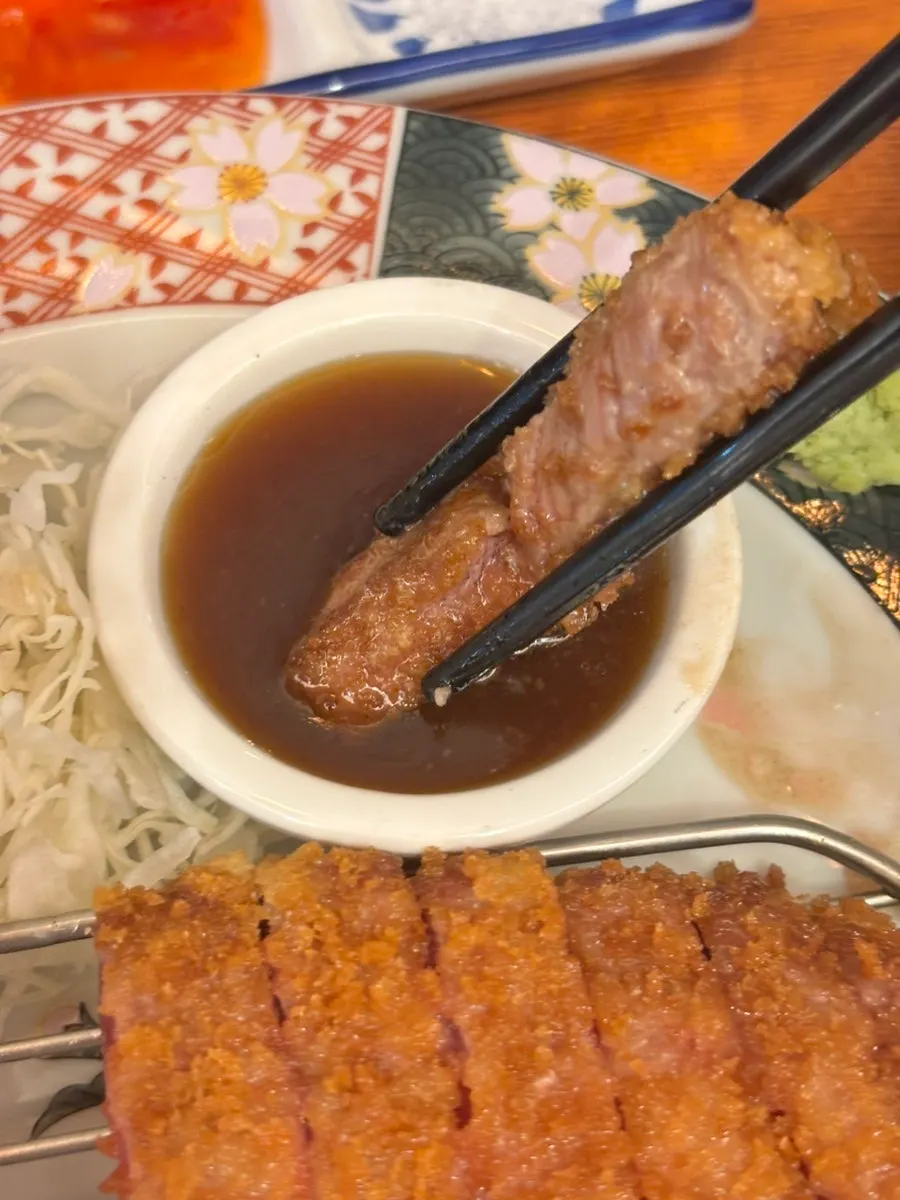 A piece of gyukatsu cooking on the hot stone