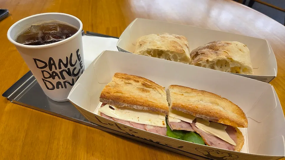 Baguette sandwich, ciabatta, and iced Americano spread