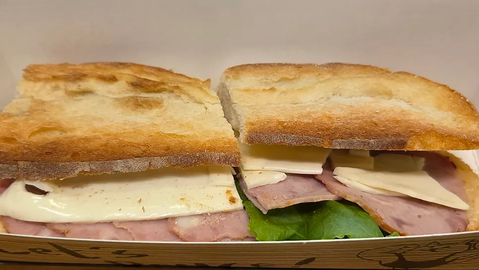 Plain baguette sandwich with ham, cheese, and lettuce