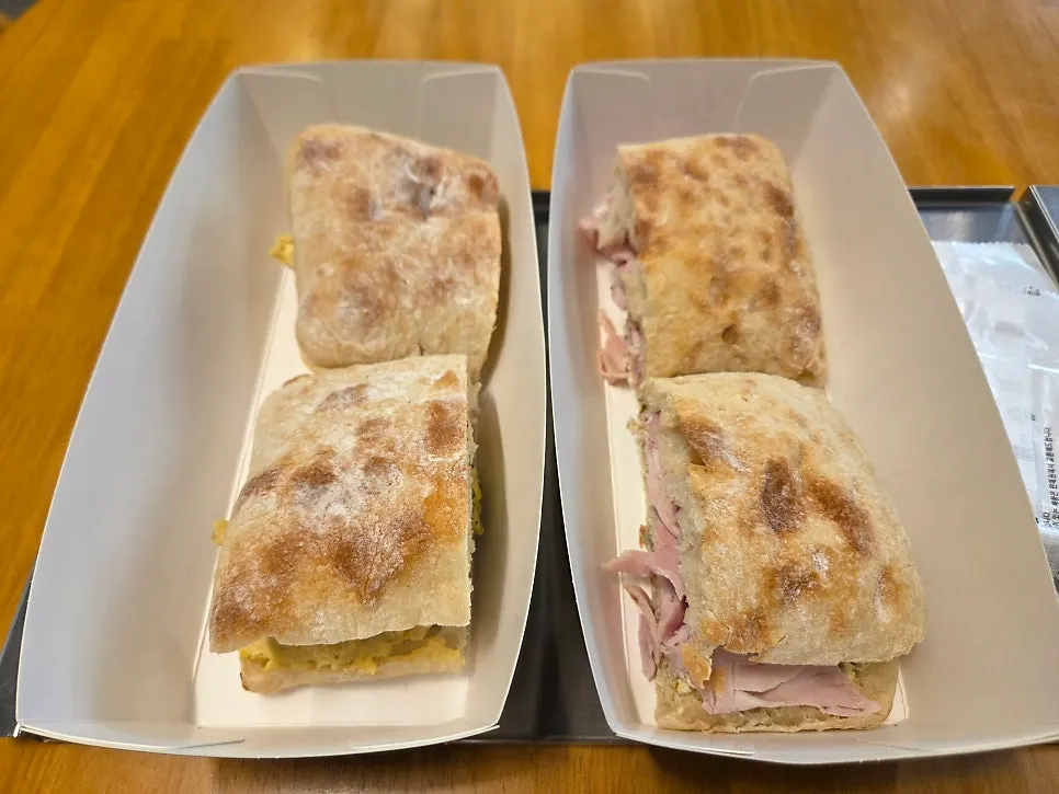 Two sandwiches served in paper boxes