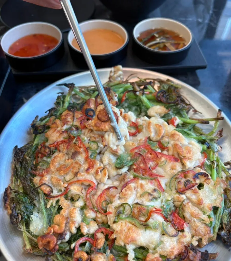 Round minari gonyi jeon topped with watercress