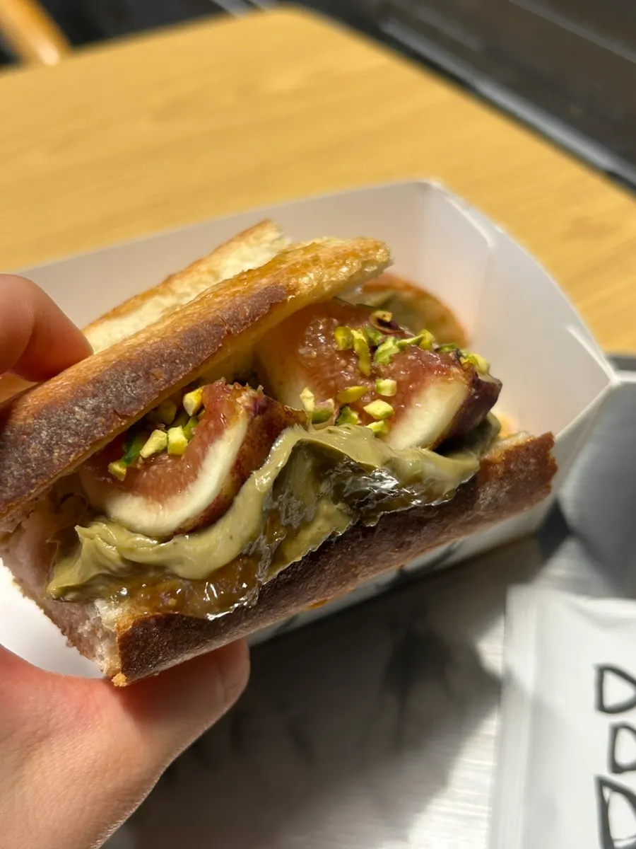 Sandwich showing fig jam and pistachio crumble